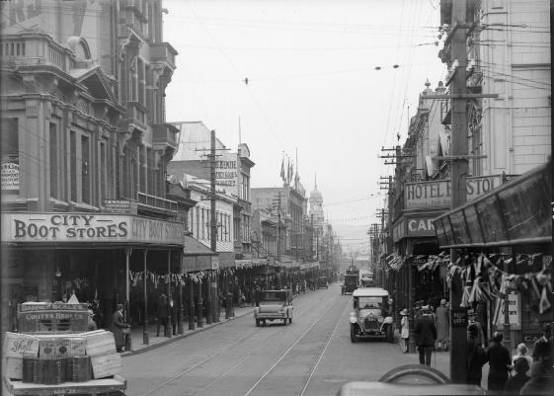Looking down Cuba Street at the intersection of Ghuznee Street ca 1923-1928, with City Boot Store on the left. On the opposite side is Hotel Bristol and Carter & Co. (This section of the Hotel Bristol was replaced by the Bristol Court in 1982). Ghuznee Street runs to the left and right in the foreground.  National Library reference: Cuba Street, Wellington. Smith, Sydney Charles, 1888-1972 :Photographs of New Zealand. Ref: 1/2-048945-G. Alexander Turnbull Library, Wellington, New Zealand. http://natlib.govt.nz/records/23119940