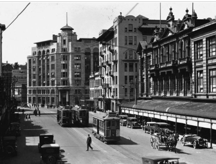 1920s – Kirkcaldie and Stains in the foreground with the Midland Hotel to the left, note the ornately detailed central section of the Kirkcaldie’s building designed by Thomas Turnbull & Son in 1897, and the original bull-nosed verandah. View of Lambton Quay, Wellington, looking towards the Midland Hotel. Original photographic prints and postcards from file print collection, Box 4. Ref: PAColl-5744-09. Alexander Turnbull Library, Wellington, New Zealand. http://natlib.govt.nz/records/23216802